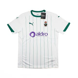 A white Puma Racing Santander home soccer jersey with green pinstripes, green collar and sleeve trim, featuring the purple Aldro sponsor logo on the front.