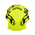 Bright yellow long-sleeve soccer jersey with 'DORTMUND' printed in black across the upper back, featuring bold black graphic patterns running down both sleeves, shown flat on a white background.