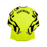 Bright yellow long-sleeve soccer jersey with 'DORTMUND' printed in black across the upper back, featuring bold black graphic patterns running down both sleeves, shown flat on a white background.