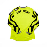 Bright yellow long-sleeve soccer jersey with 'DORTMUND' printed in black across the upper back, featuring bold black graphic patterns running down both sleeves, shown flat on a white background.