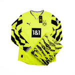 A Borussia Dortmund soccer jersey in a box in neon yellow with black graphic patterns, featuring the Puma logo, BVB 09 crest, and 1&1 sponsor logo on a white background.