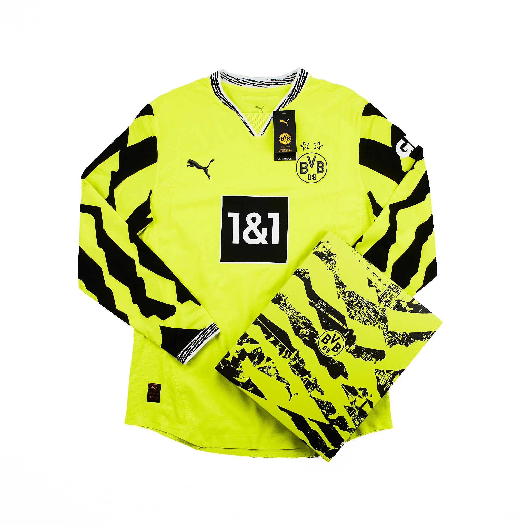 A Borussia Dortmund soccer jersey in a box in neon yellow with black graphic patterns, featuring the Puma logo, BVB 09 crest, and 1&1 sponsor logo on a white background.