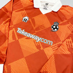 2024/25 Takeaway.com Cult Kits football jersey in orange, featuring brand logo, collared design, and geometric pattern.