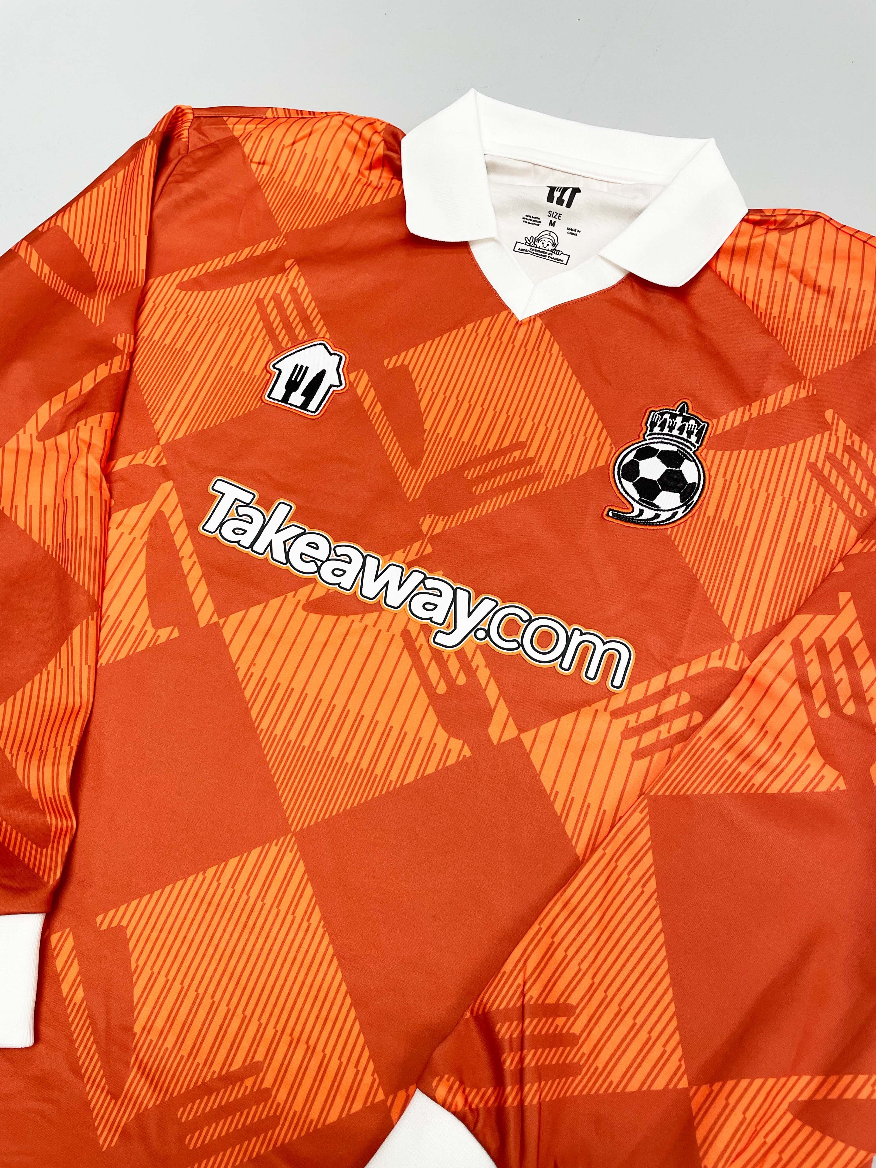 2024/25 Takeaway.com Cult Kits football jersey in orange, featuring brand logo, collared design, and geometric pattern.
