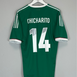 Green sports jersey with 'Chicharito' and number '14' on a hanger against a gray background