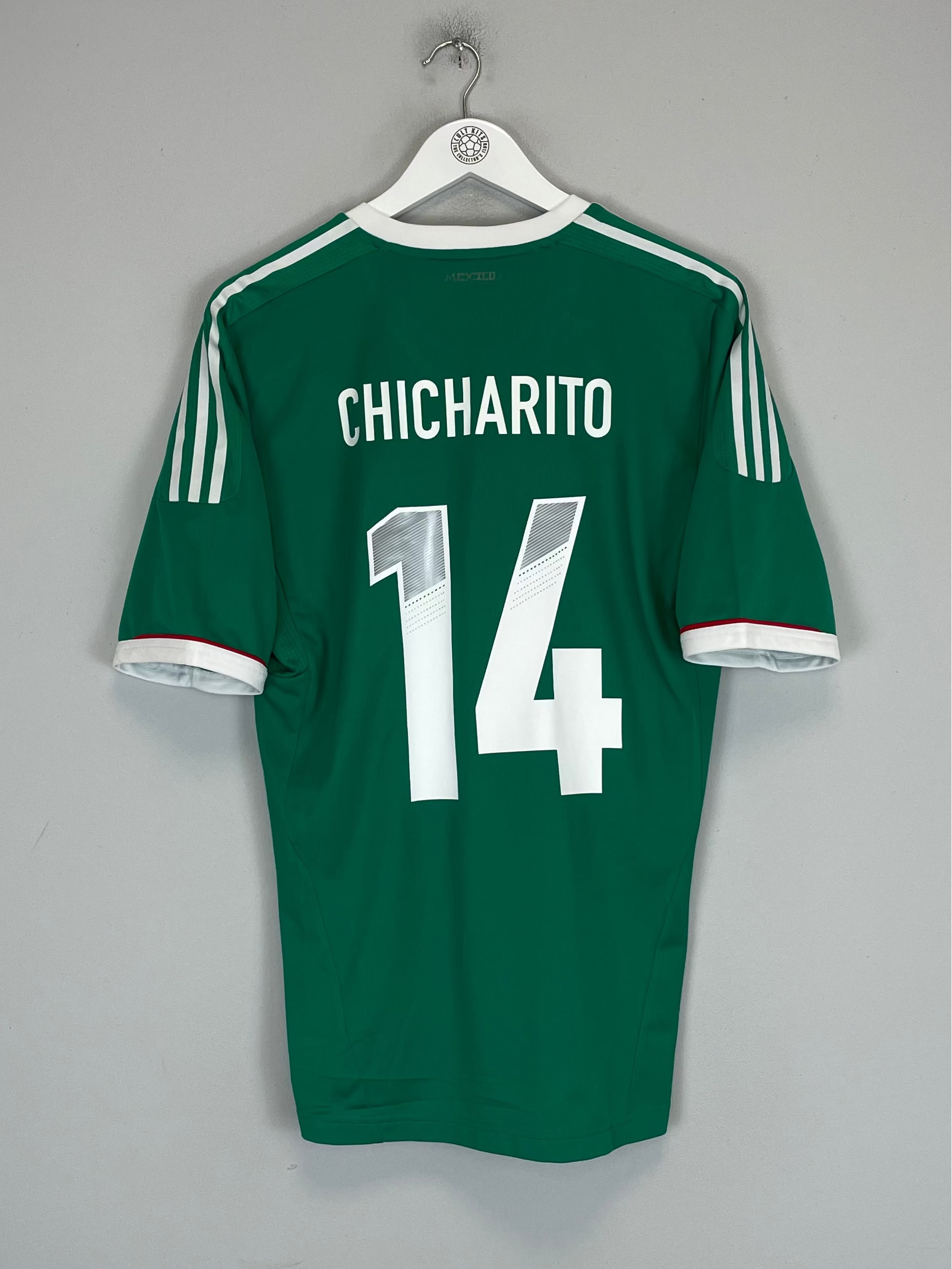 Green sports jersey with 'Chicharito' and number '14' on a hanger against a gray background