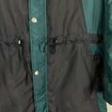 Close-up of a black and teal 1992/93 Ajax bench coat by Umbro, showcasing buttons and drawstrings at the waist.