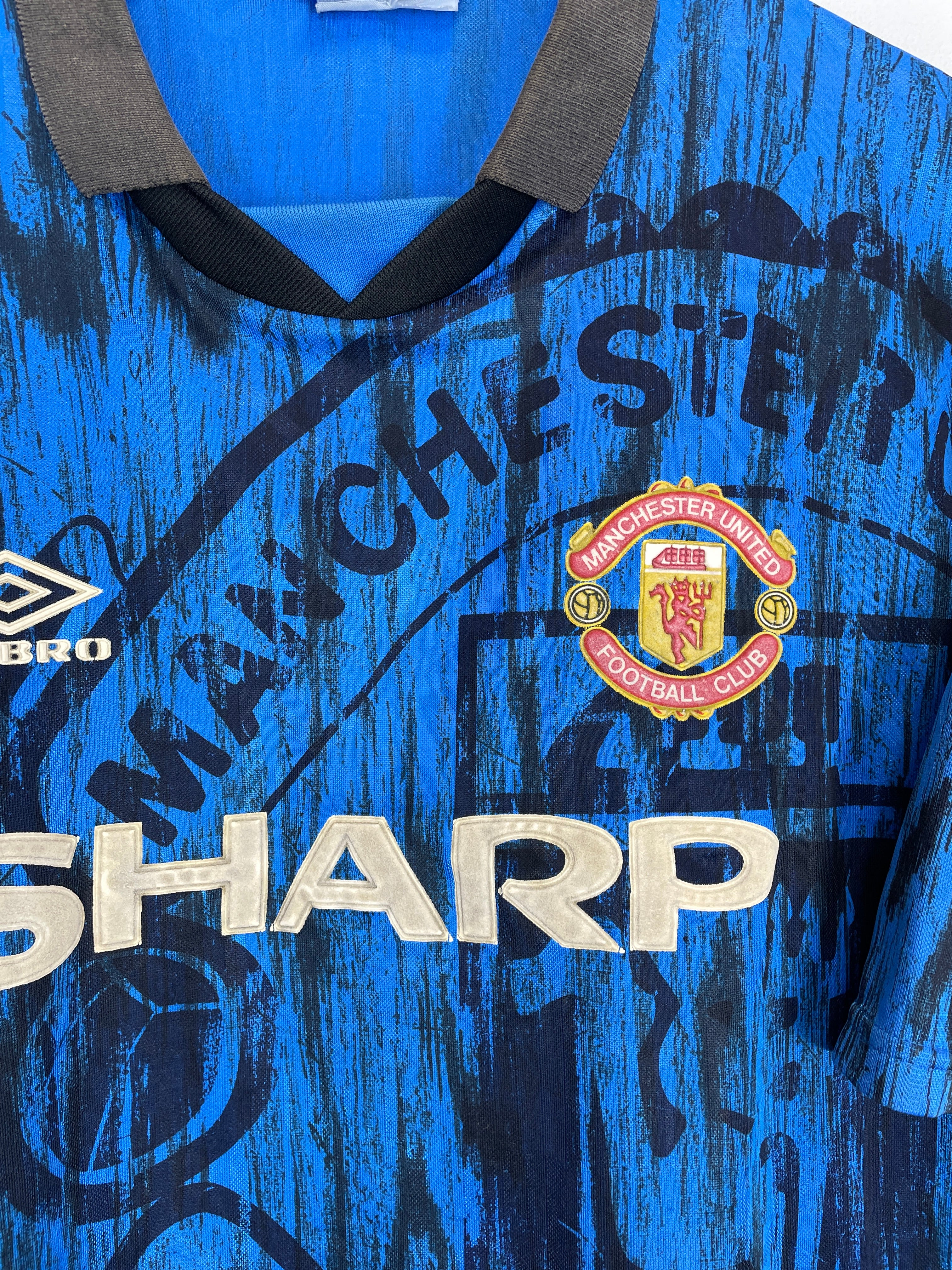1992/93 Manchester United away shirt by Umbro in vibrant blue, featuring sponsor Sharp and iconic club crest. Size XL.