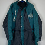 1992/93 Ajax Umbro Bench Coat in XL, teal and black, featuring team logo and manufacturer branding, in very good condition.
