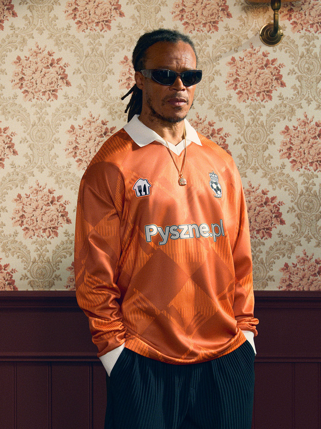 2024/25 Pyszne.pl Cult Kits football jersey worn by model, showcasing vibrant orange color, celebrating UEFA Champions League Final.