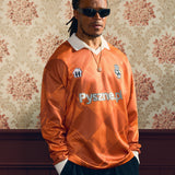 2024/25 Pyszne.pl Cult Kits football jersey worn by model, showcasing vibrant orange color, celebrating UEFA Champions League Final.